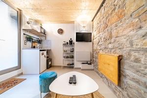 un soggiorno con tavolo bianco e parete in pietra di Le petit Victor Hugo - studio Bellecour a Lione