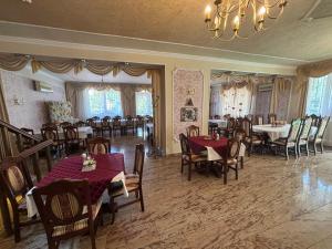 a dining room with tables and chairs and a chandelier at Parish Bull Hotel in Kisvárda