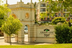 a building with a clock tower in front of a building at Green Life Apartments Sozopol in Sozopol