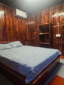 ein Schlafzimmer mit einem Bett mit einer Holzwand in der Unterkunft Homestay Trương Khang Ocean in Ấp Thiện Sơn