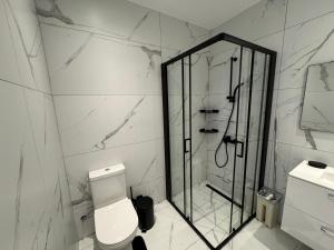 a white bathroom with a shower and a toilet at SWIFT Suites Limassol in Limassol +70 photos
