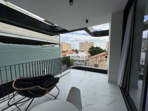 a balcony with a chair and a view of a city at SWIFT Suites Limassol in Limassol