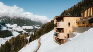 a building on the side of a snow covered mountain at Lahnerhof Chalets in Lutago