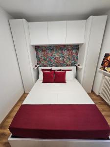 a bedroom with a white bed with red pillows at Rubin Stay-Karabas Apartments in Vicenza