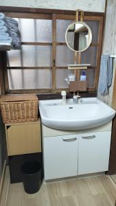 a bathroom with a sink and a mirror at 古民家ふるさと真鶴 in Wada