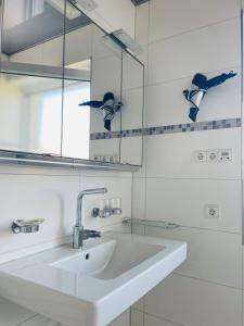 a white bathroom with a sink and a mirror at ZU HAUSE Pfalz in Bad Dürkheim