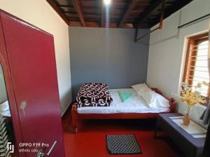 a small bedroom with a bed in a room at Divine home stays in Madikeri
