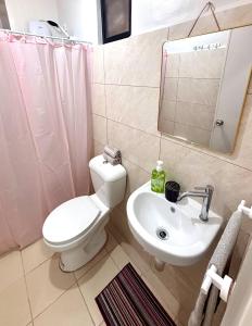 ein Badezimmer mit Toilette, Waschbecken und Spiegel in der Unterkunft Peaceful Panglao Escape for Families Couples in Dao