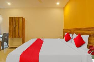 a bedroom with a large bed with red pillows at Hotel O R Square in Warangal +20 photos