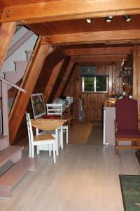 a room with a table and a kitchen in a cabin at Sunny Bluffs Chalets in Kaslo