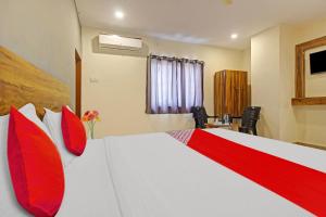 a bedroom with a large bed with red pillows at Hotel O R Square in Warangal