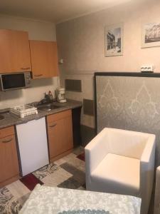 a small kitchen with a sink and a white chair at Harzbett in Sinsleben