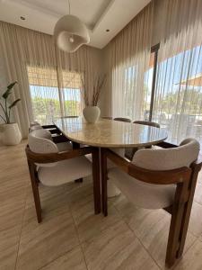 une salle à manger avec une table et des chaises en verre dans l'établissement Luxury family villa with private pool, à Douar bel Rhanodour