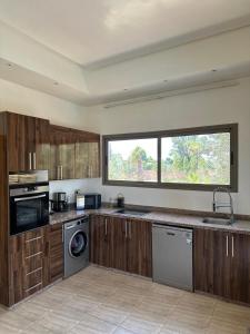 une grande cuisine avec des placards en bois et une fenêtre dans l'établissement Luxury family villa with private pool, à Douar bel Rhanodour