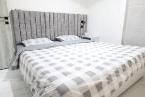 a bedroom with a large bed with a checkered blanket at ريلاكس للاجنحة الفندقية in Amman