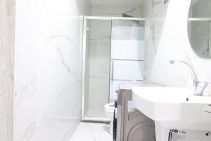 a white bathroom with a sink and a shower at ريلاكس للاجنحة الفندقية in Amman +4 photos