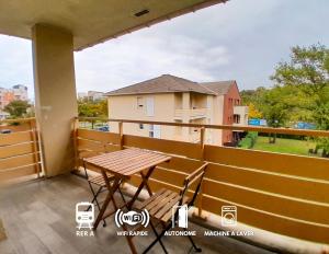 a balcony with a table and a view of a building at Calme & spacieux, RER A 3 min, Parking, 2 salles d'eau in Achères