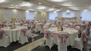 a banquet hall with white tables and pink bows at Parish Bull Hotel in Kisvárda