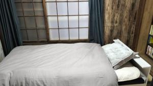 a bed in a room with a window at 古民家ふるさと真鶴 in Wada
