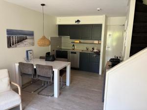 Una cocina con una mesa y sillas en una habitación. en Strand 104, en Hollum
