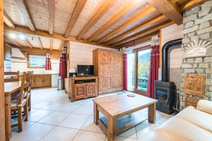 a living room with a table and a fireplace at Chalet La Petite Maison in Saint-Marcel