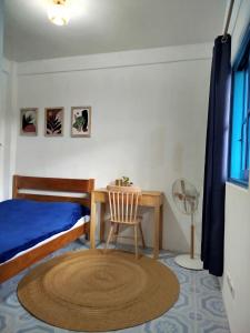 a bedroom with a bed and a desk and a chair at Hamada's Guesthouse in Baler