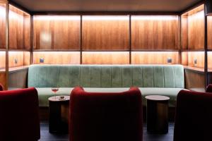 a waiting room with a green couch and two tables at 1.75 Paris Le Charme in Paris