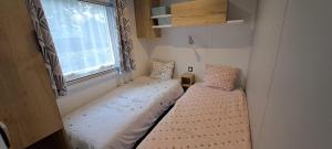 ラ・トランブラードにあるRonce les bainsの窓のある小さな部屋にベッドが2つある +32枚の写真
