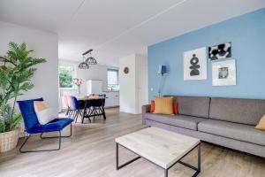 ein Wohnzimmer mit Sofa und Tisch in der Unterkunft Zonnige luxe bungalow met grote tuin in Ewijk