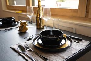 a table with a black plate and a bottle of wine at Alpin Chalet in Bürserberg