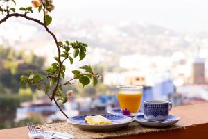 a plate of food and a glass of orange juice at Dar Rass El Maa in Chefchaouen