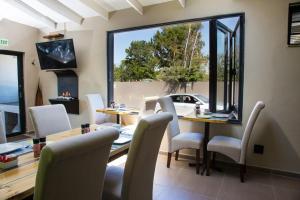 een eetkamer met een tafel en stoelen en een open haard bij Pinto City Motel East London in East London