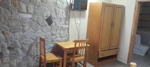 a room with a table and two chairs and a stone wall at Ashara guesthouse in Āwasa +6 photos