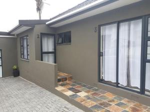 een huis met een groot raam en een tegelvloer bij Pinto City Motel East London in East London