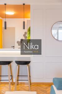 a dining room with a table and two stools at Apartman Nika in Pirot