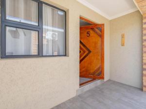 a wooden door in a room with a window at Kuhle Guesthouse in Kempton Park
