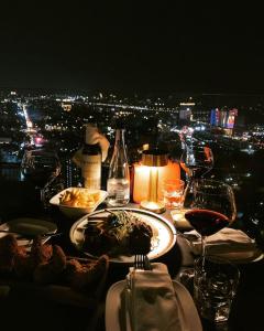 a table with plates of food and glasses of wine at Light Vesper Premium Hotel & Sky Bar in Ho Chi Minh City