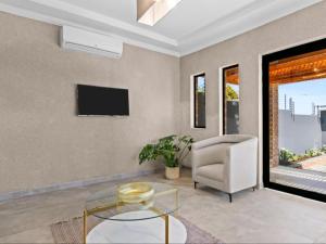 a living room with a tv and a chair at Kuhle Guesthouse in Kempton Park