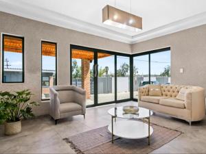 a living room with a couch and two chairs and a table at Kuhle Guesthouse in Kempton Park