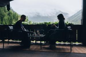 a man and woman sitting at a table looking out a window at Boutique Hotel Mandarfnerhof in Sankt Leonhard im Pitztal
