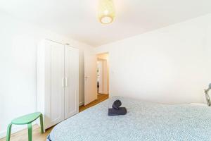 a white bedroom with a bed and a blue blanket at Calm & Comfort at the Gates of Lyon 2-bedroom apartment in Sainte-Foy in Sainte-Foy-lès-Lyon +11 photos