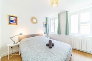 a bedroom with a bed and a lamp and windows at Calm & Comfort at the Gates of Lyon 2-bedroom apartment in Sainte-Foy in Sainte-Foy-lès-Lyon
