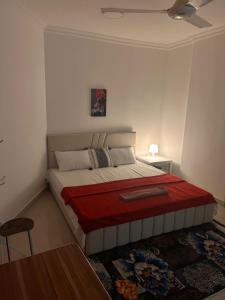 a bedroom with a bed with a red blanket at Bait Alhoor in Muscat