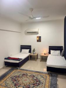 a bedroom with two beds and a rug at Bait Alhoor in Muscat
