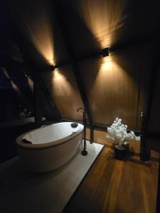 a bathroom with a tub in a room with lights at Cabana Fé Miguel Pereira Com Ofuro e Por do Sol in Miguel Pereira