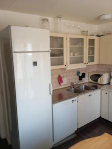 スカーラにあるLägenhete centrala Skaraの白い冷蔵庫とシンクのあるキッチン