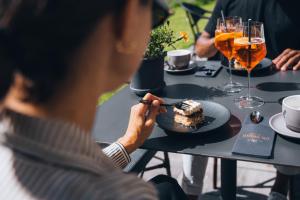 a man sitting at a table eating a piece of cake at Boutique Hotel Mandarfnerhof in Sankt Leonhard im Pitztal