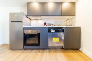 una cocina con electrodomésticos de acero inoxidable en una habitación en Le Pablo charming 6 pers Sainte-Foy-lès-Lyon, en Sainte-Foy-lès-Lyon