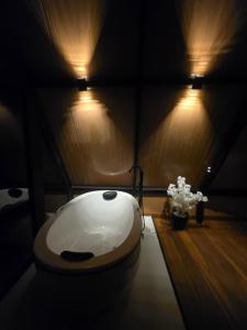 a bathroom with a toilet in a room with lights at Cabana Fé Miguel Pereira Com Ofuro e Por do Sol in Miguel Pereira
