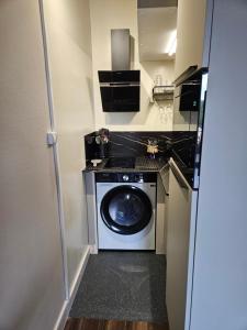 アングレットにあるRésidence Chiberta Anglet océan golf surfの小さな部屋に洗濯機と乾燥機があります。